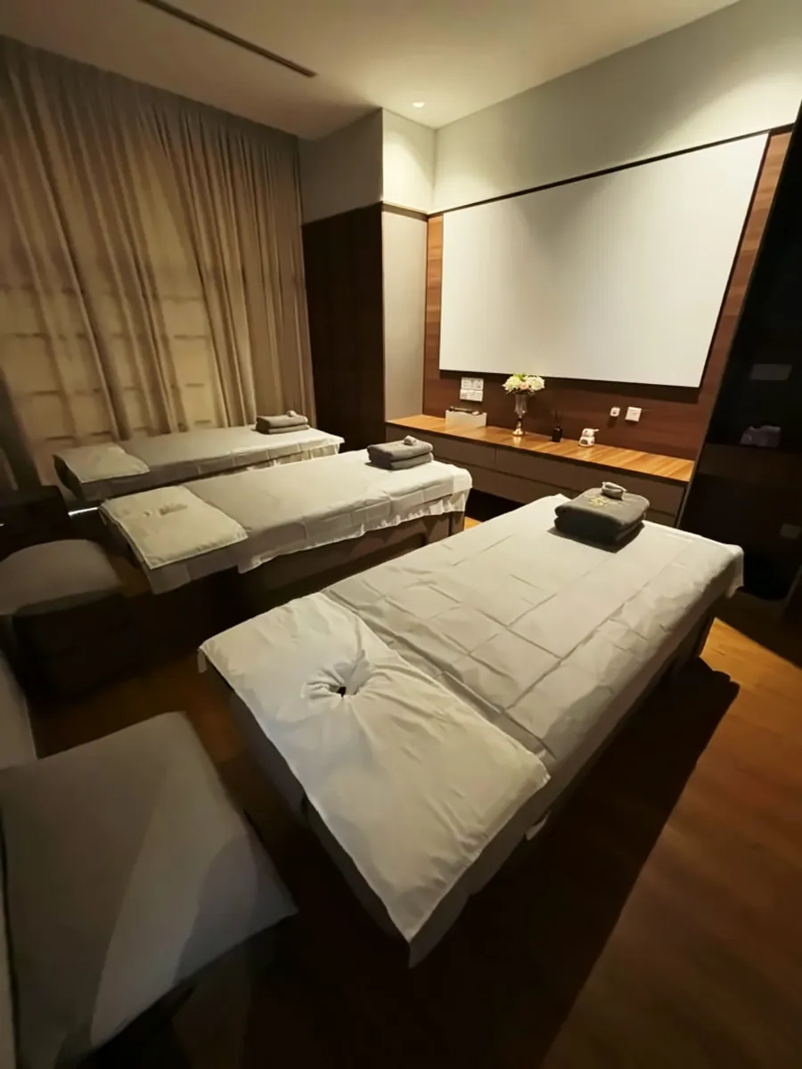 Three-bed treatment room facing a projection screen at Aurea, Bukit Jalil